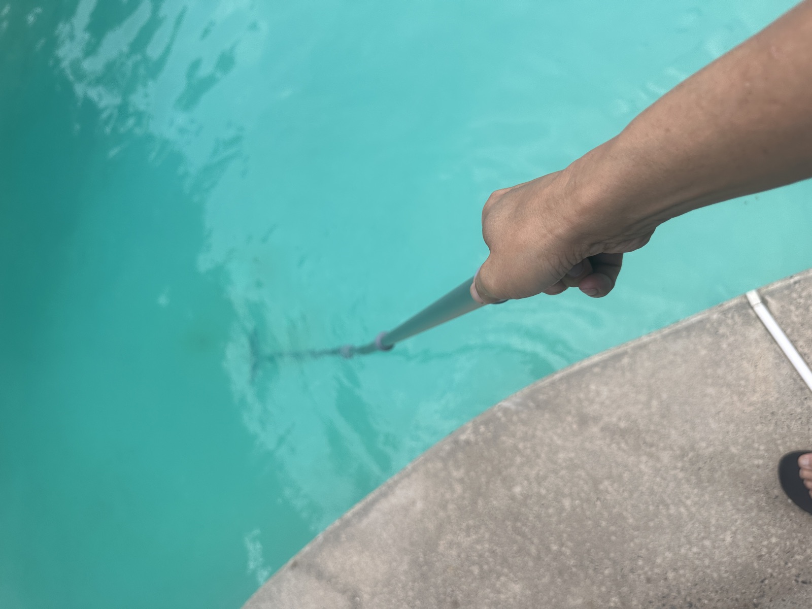 Skimming the surface of a clear blue pool with the Sepetrel pole at full extension.
